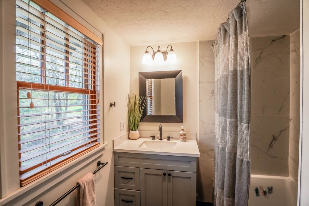Bathroom vanity, tile shower surround, and freestanding tub from a Renewed Construction remodel