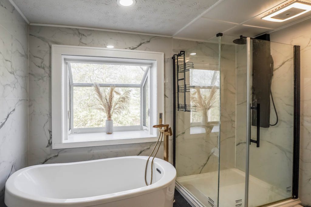 Freestanding tub and marble-look tile shower surround, a Renewed Construction bathroom tile project